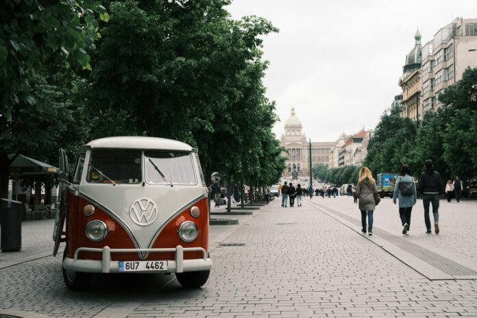Vintage red volkswagen van parked on city street.
